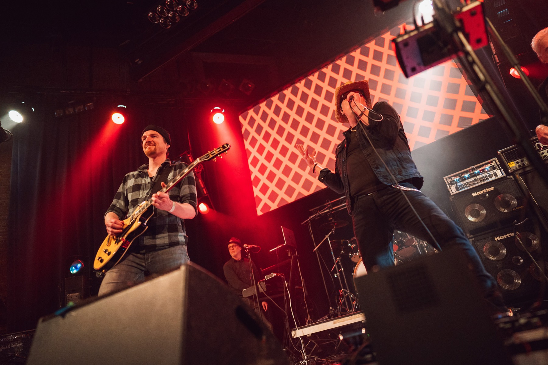 Gitarist en zanger op een roodverlicht podium
